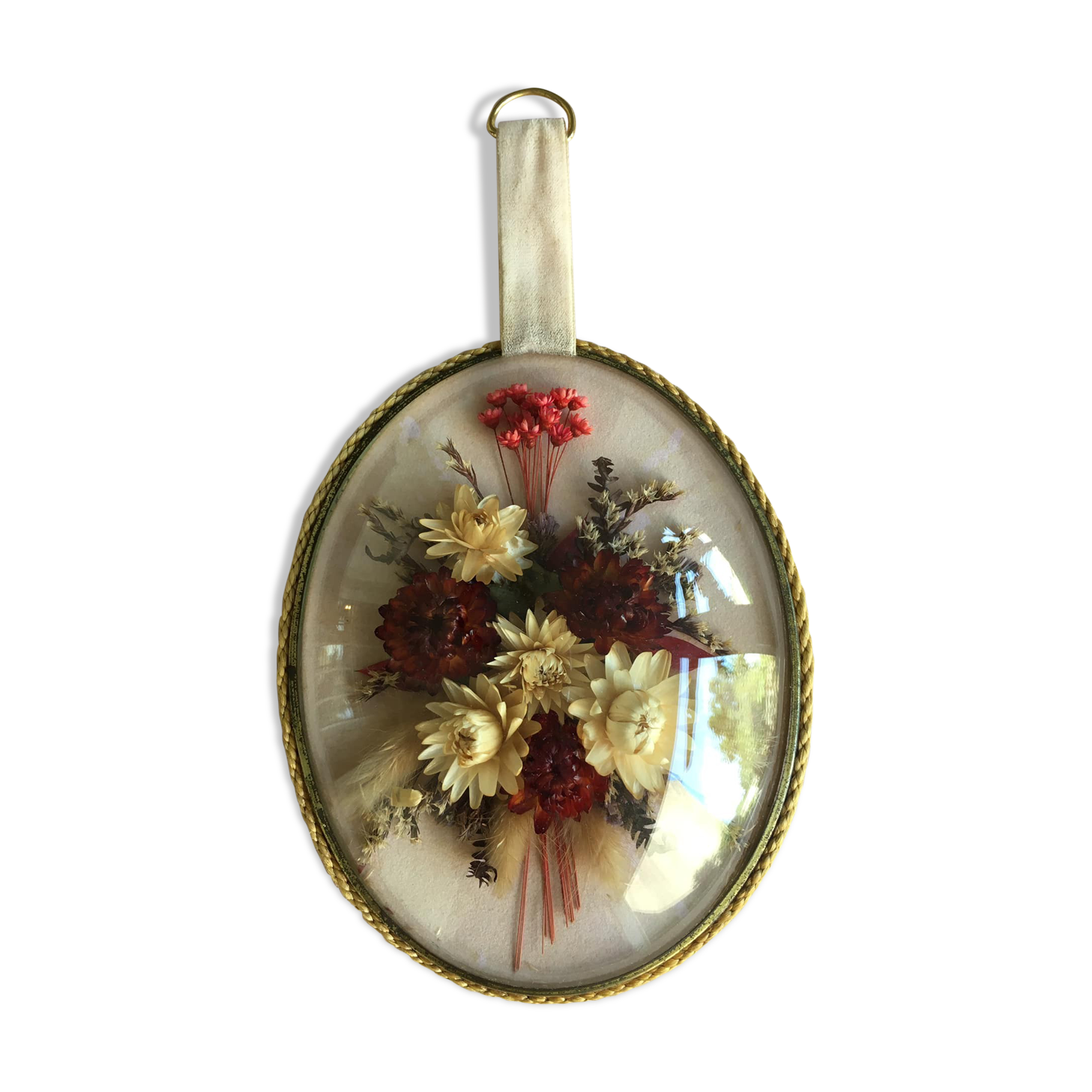 Old medallion frame of dried flowers of oval shape. To hang with velvet stripe.