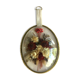 Old medallion frame of dried flowers of oval shape. To hang with velvet stripe.