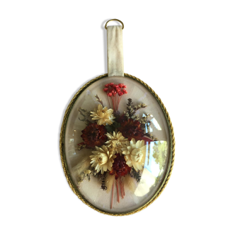Old medallion frame of dried flowers of oval shape. To hang with velvet stripe.