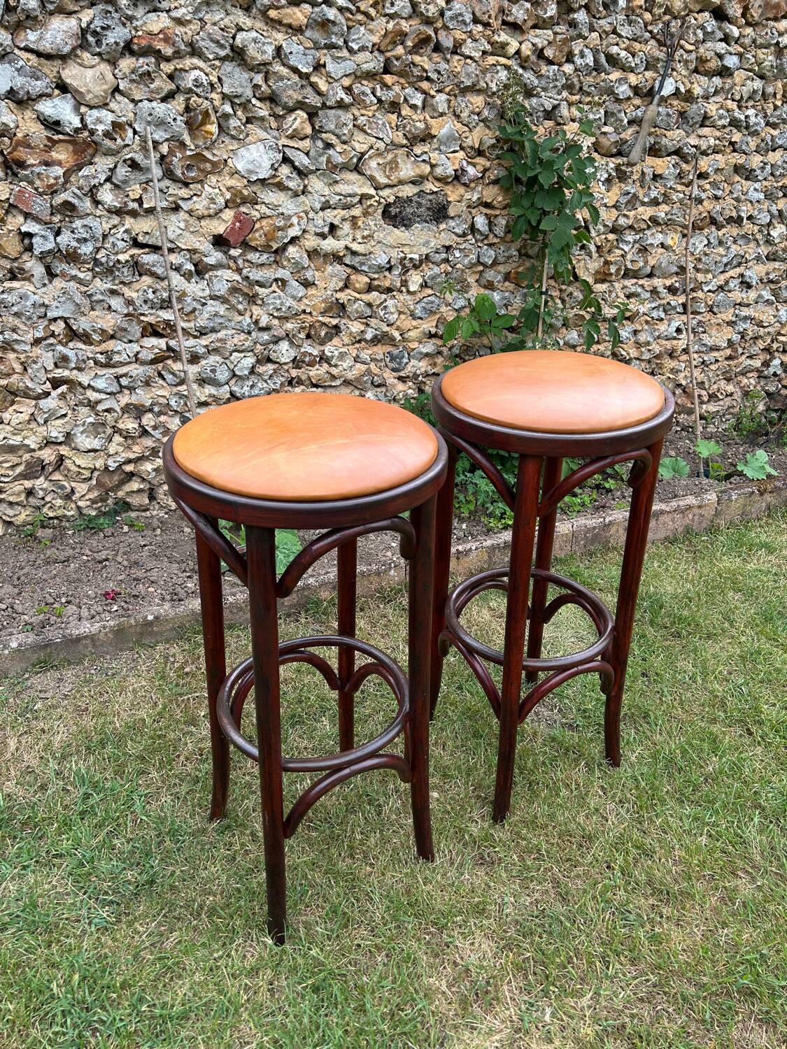 Pair of curved wooden bistro stools with leather seats