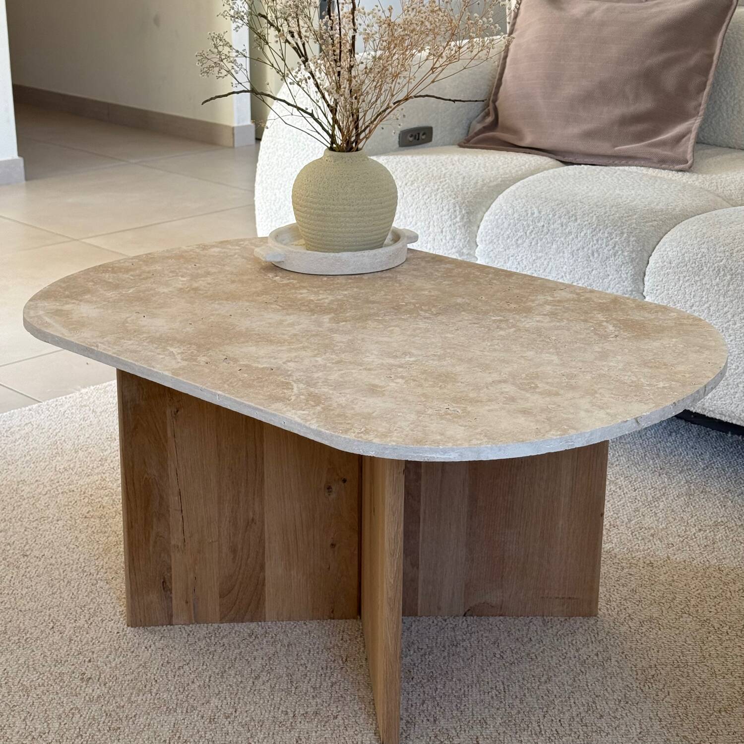 Oval coffee table in travertine and raw oak.