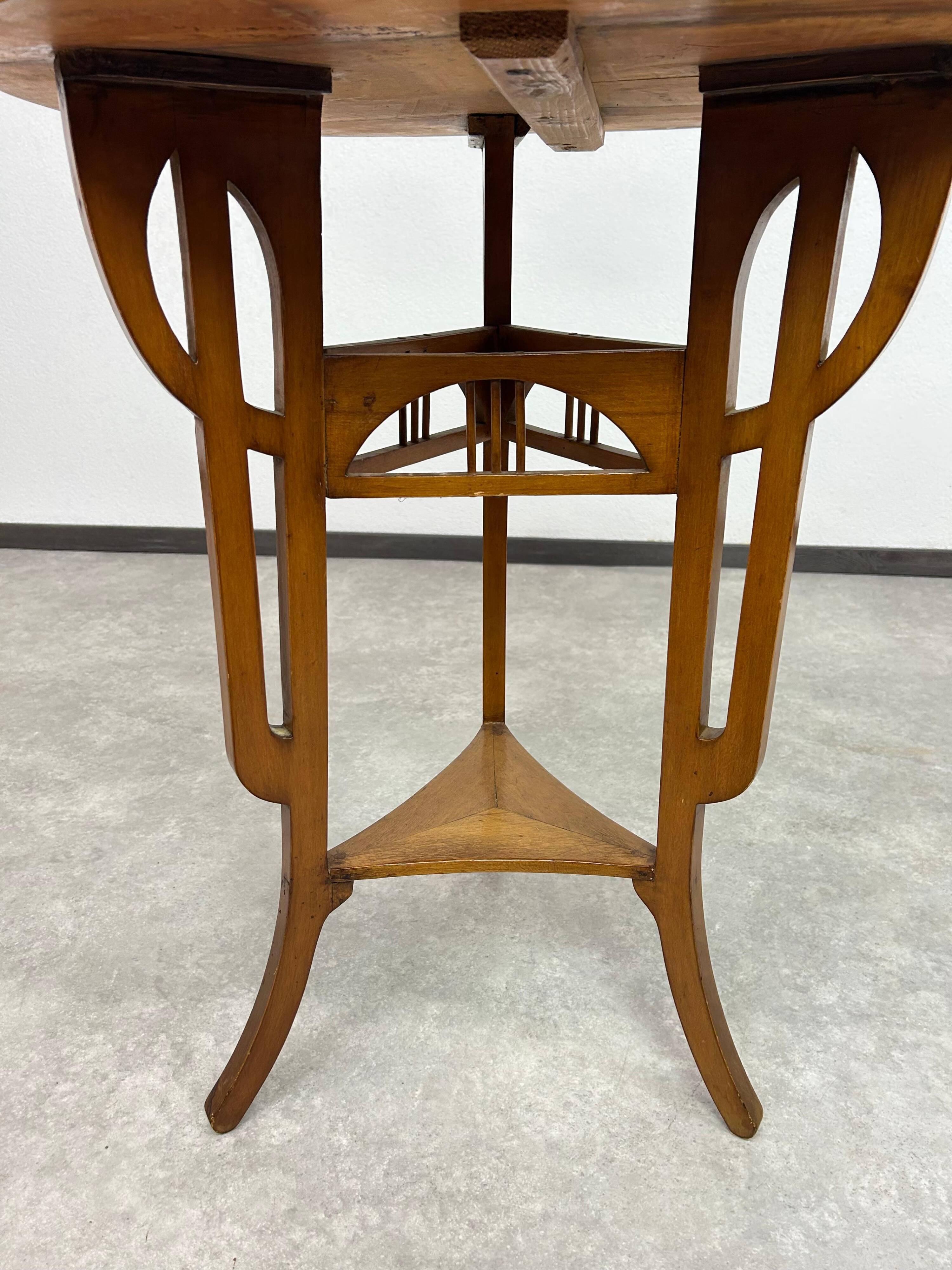 Round Art Nouveau coffee table with a sculpted top.