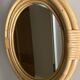Round mirror from the 1960s with a frame made of rattan and metal.