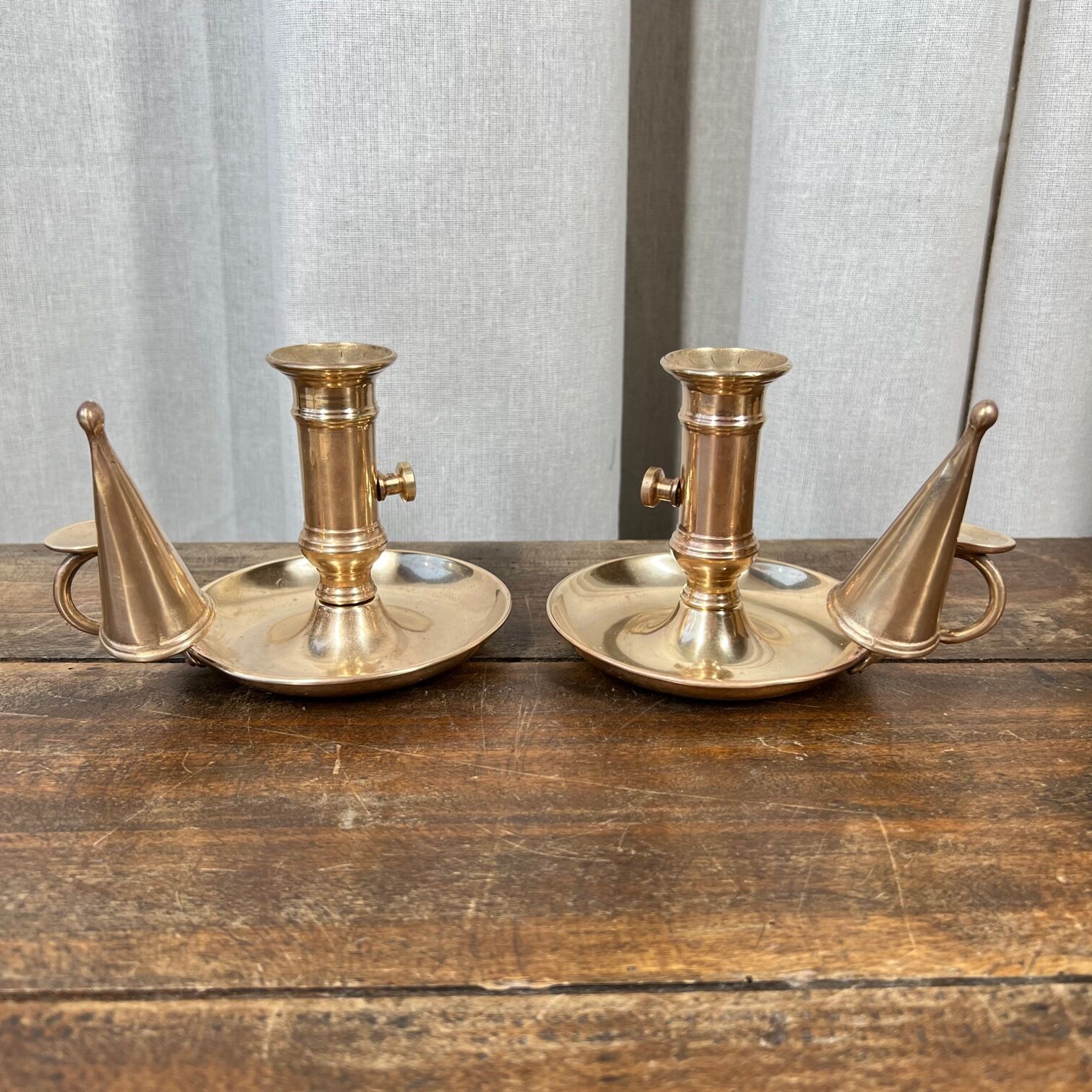 Duo of brass cellar rat candlesticks with extinguisher