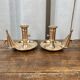 Duo of brass cellar rat candlesticks with extinguisher