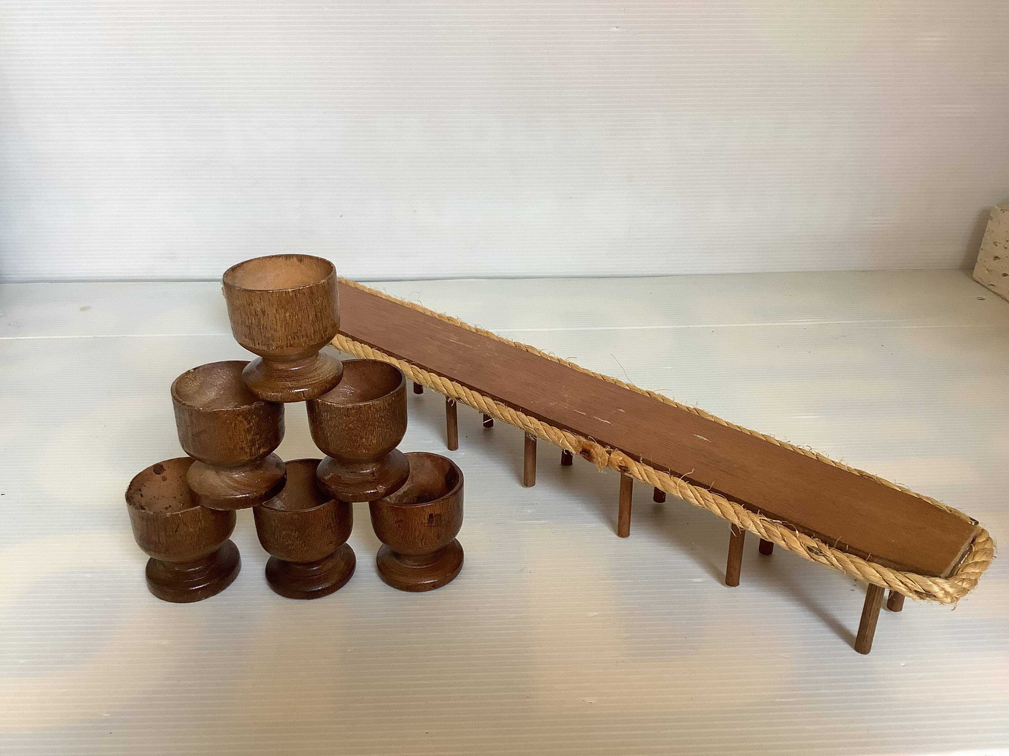 Six wooden egg cups and their rope holder
