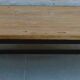 Industrial style coffee table with wooden top supported by a metal base -