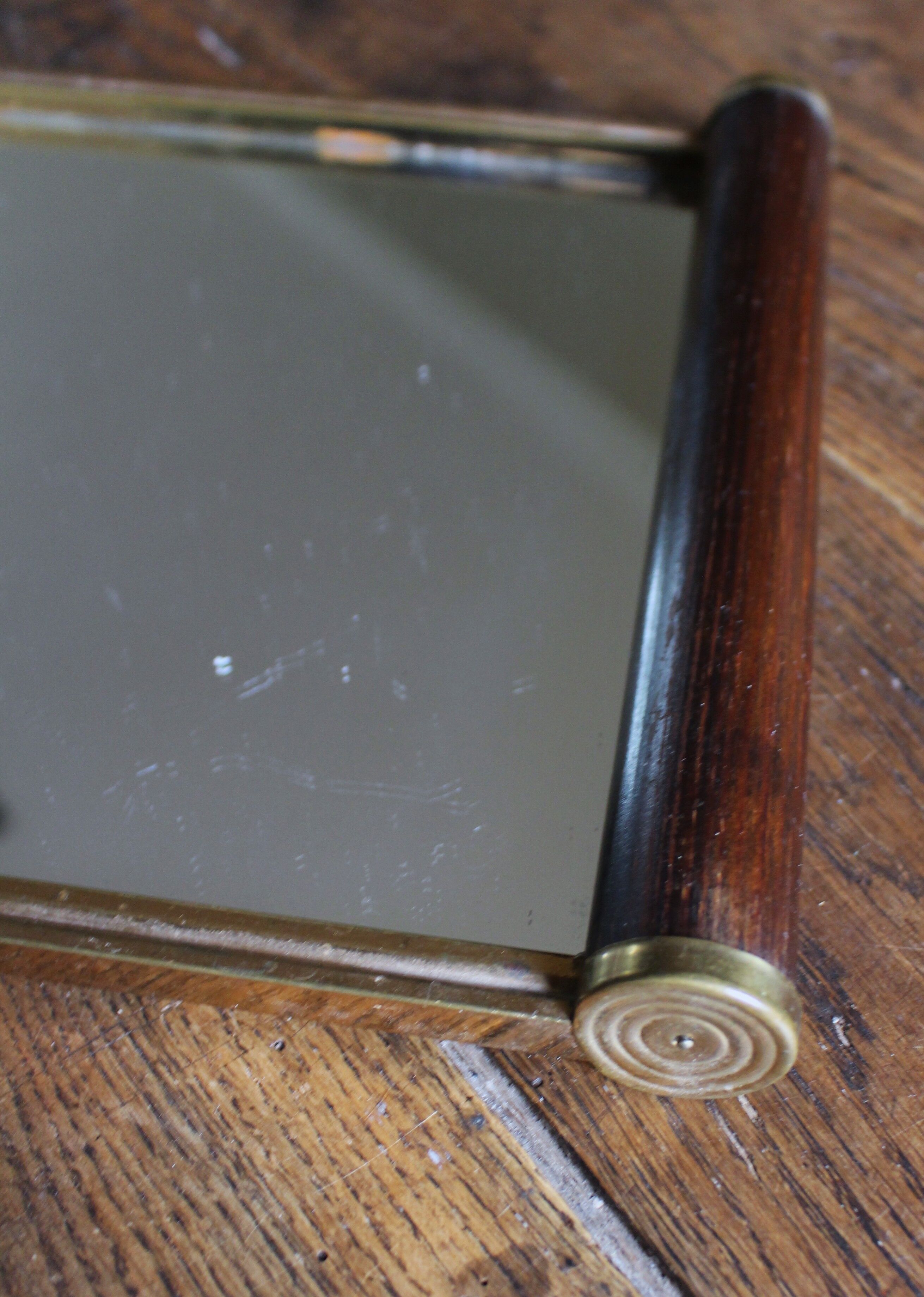 Rectangular mirror tray with wooden handles and gilding.