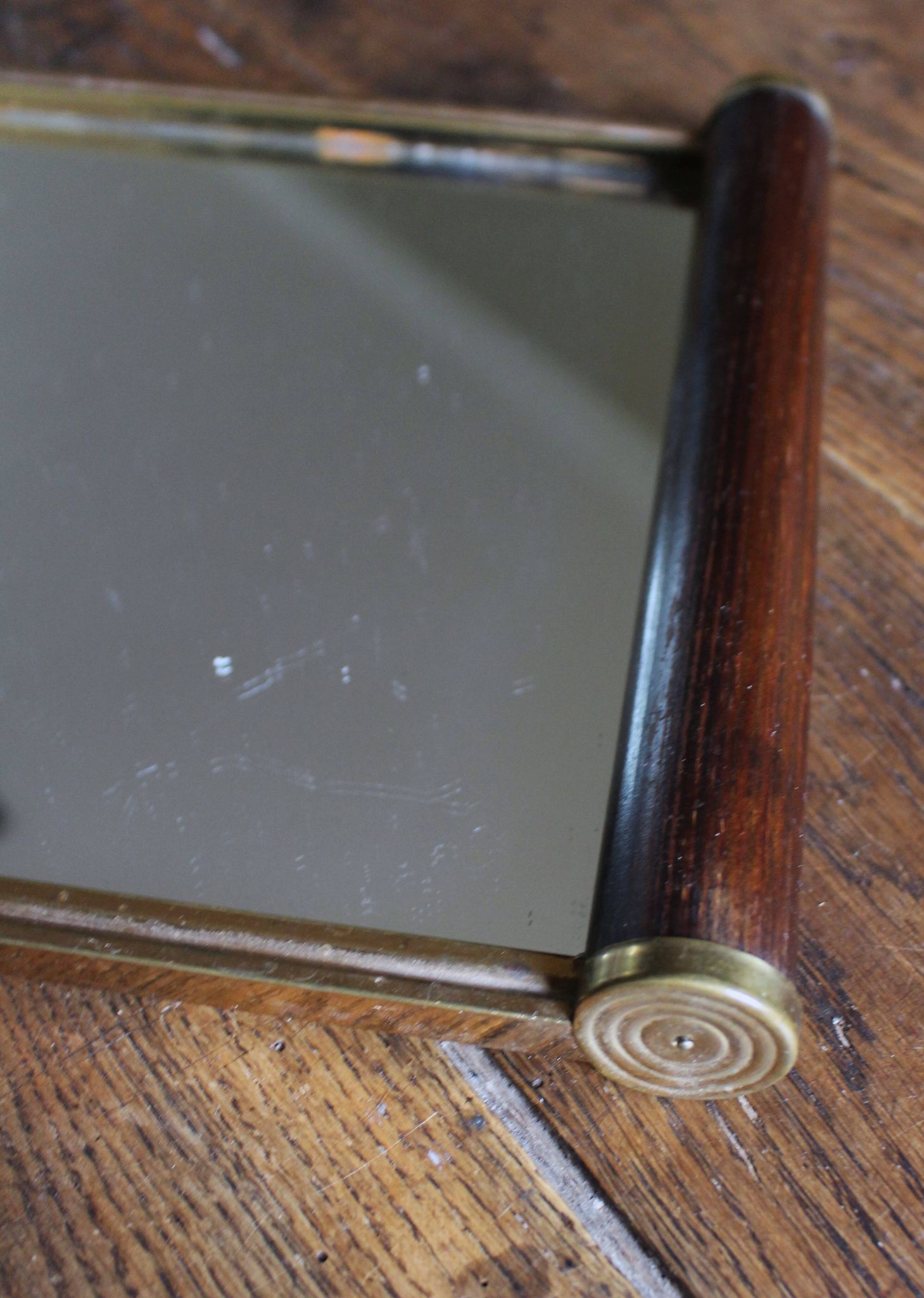 Rectangular mirror tray with wooden handles and gilding.