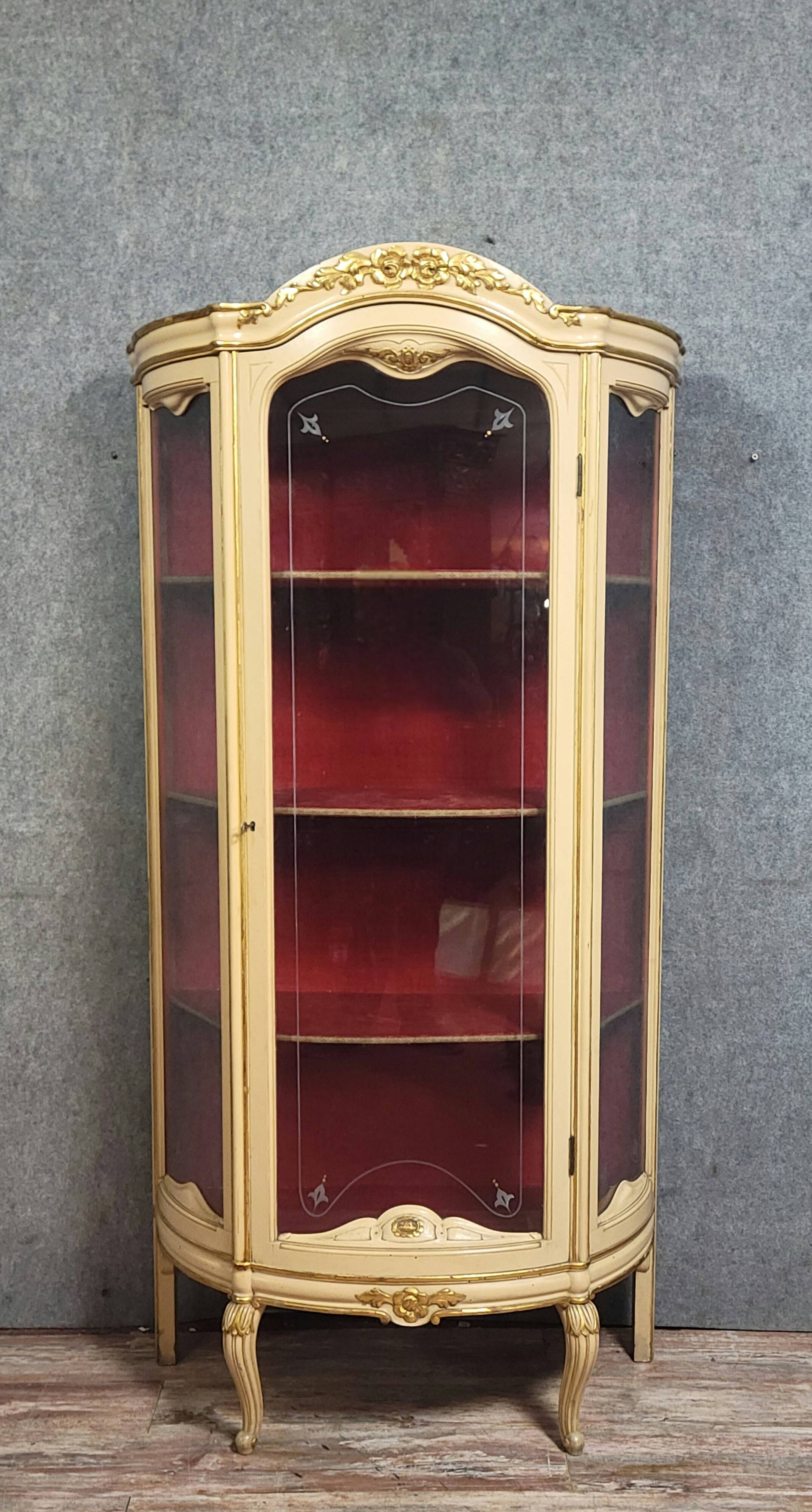 Curved display cabinet in Louis XV style, in cream lacquered wood enhanced with gilding.