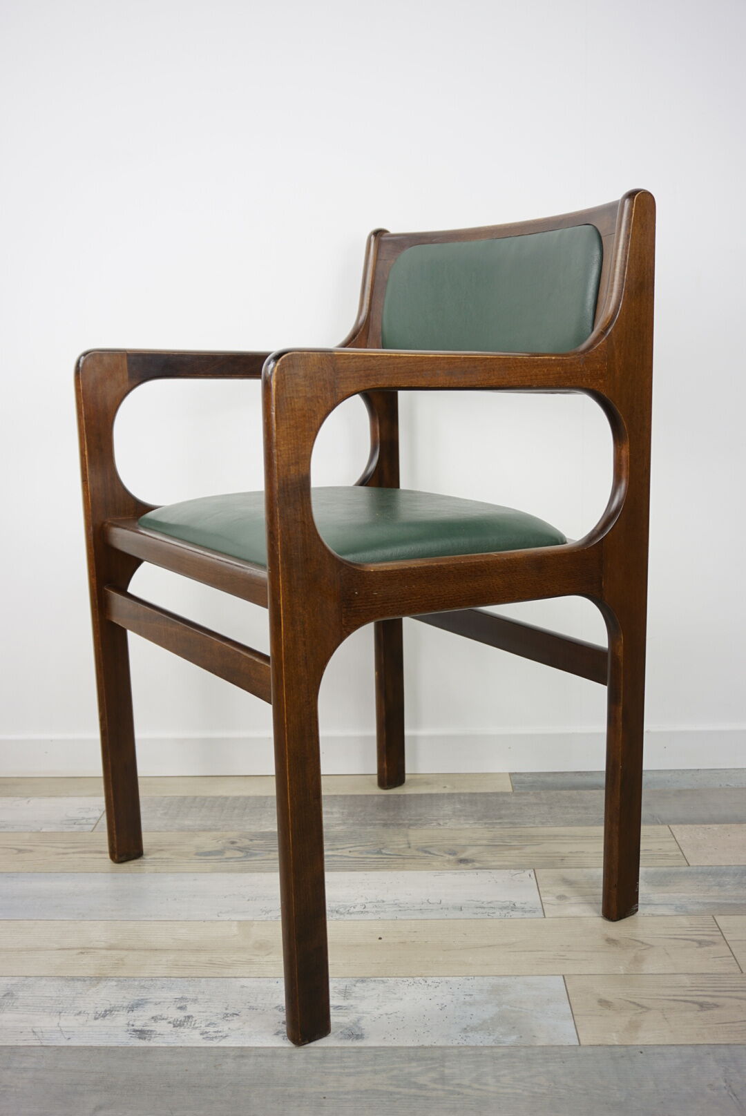Armchair of the 60s in wood and imitation dark green leather