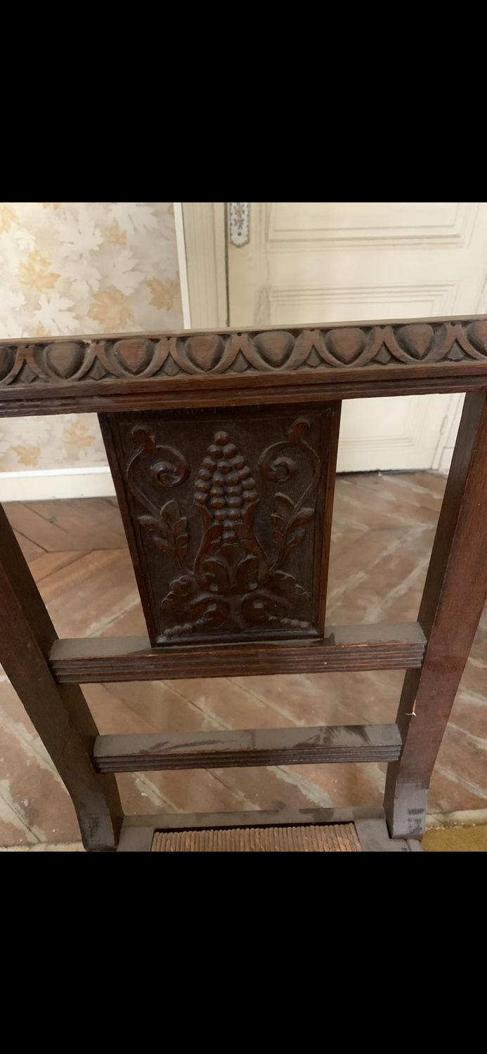 Antique carved wooden chairs with straw seats.