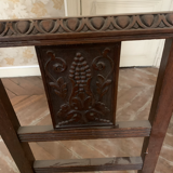 Antique carved wooden chairs with straw seats.