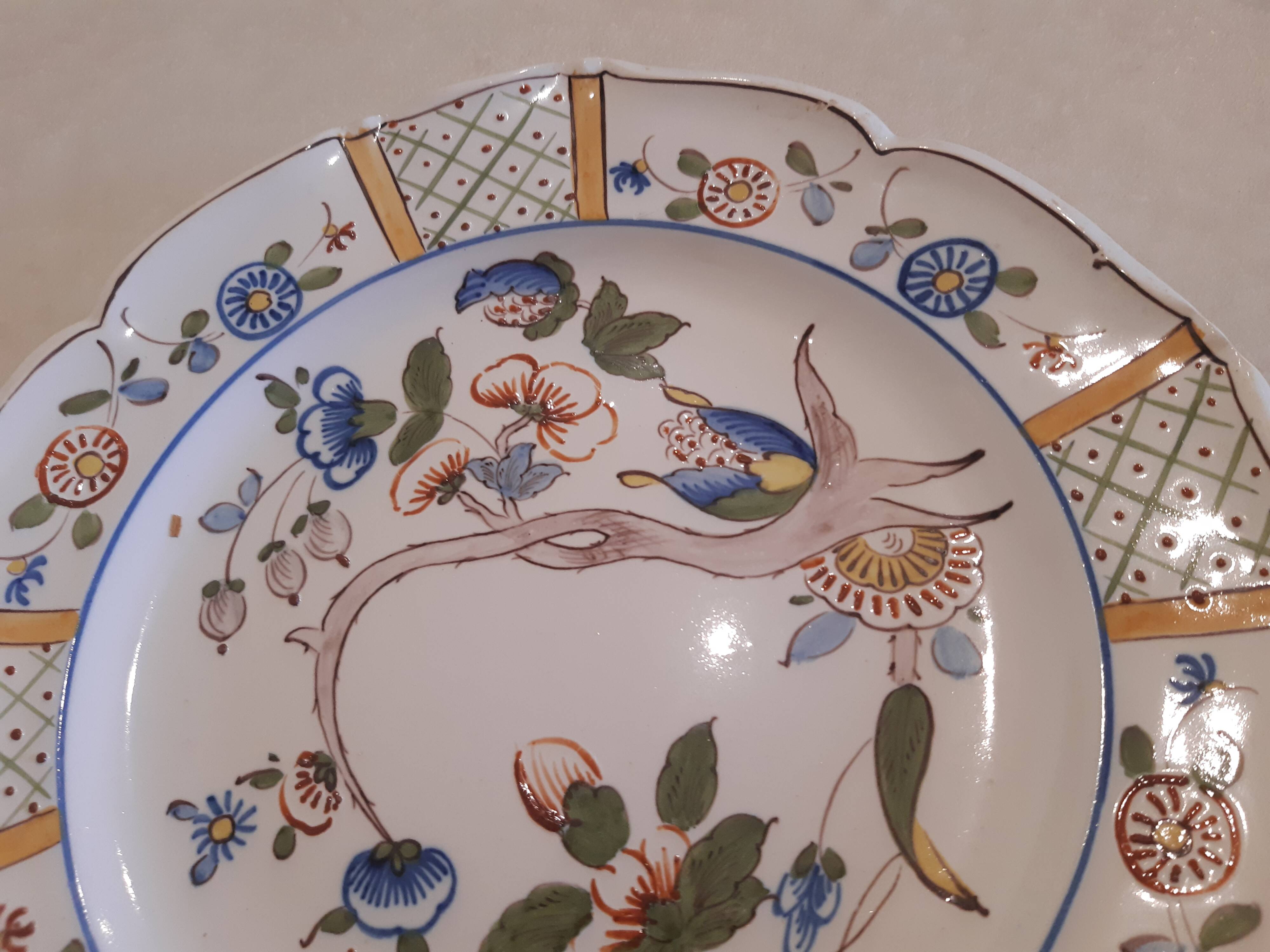 Flat plate in earthenware, hand-painted rural decoration partly in relief,