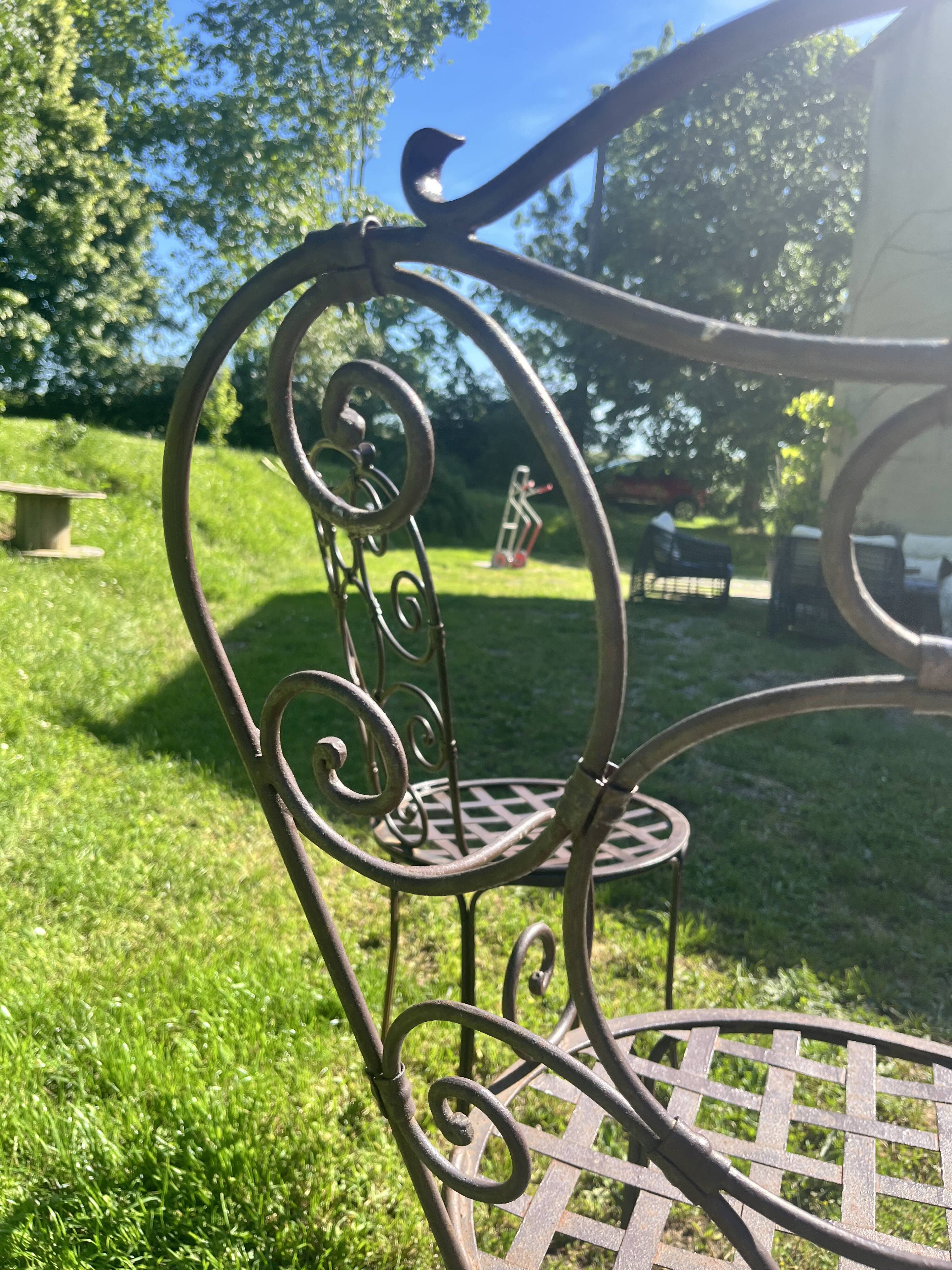 Old wrought iron table and its armchairs and chairs for outdoor use.