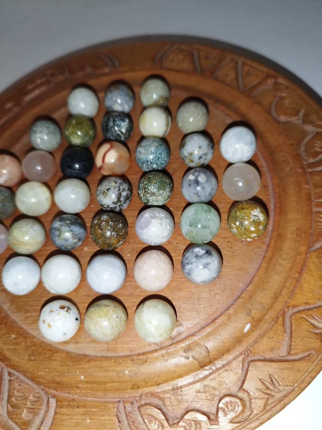 Ancient solitaire game in wood and stone marbles