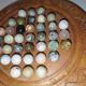 Ancient solitaire game in wood and stone marbles