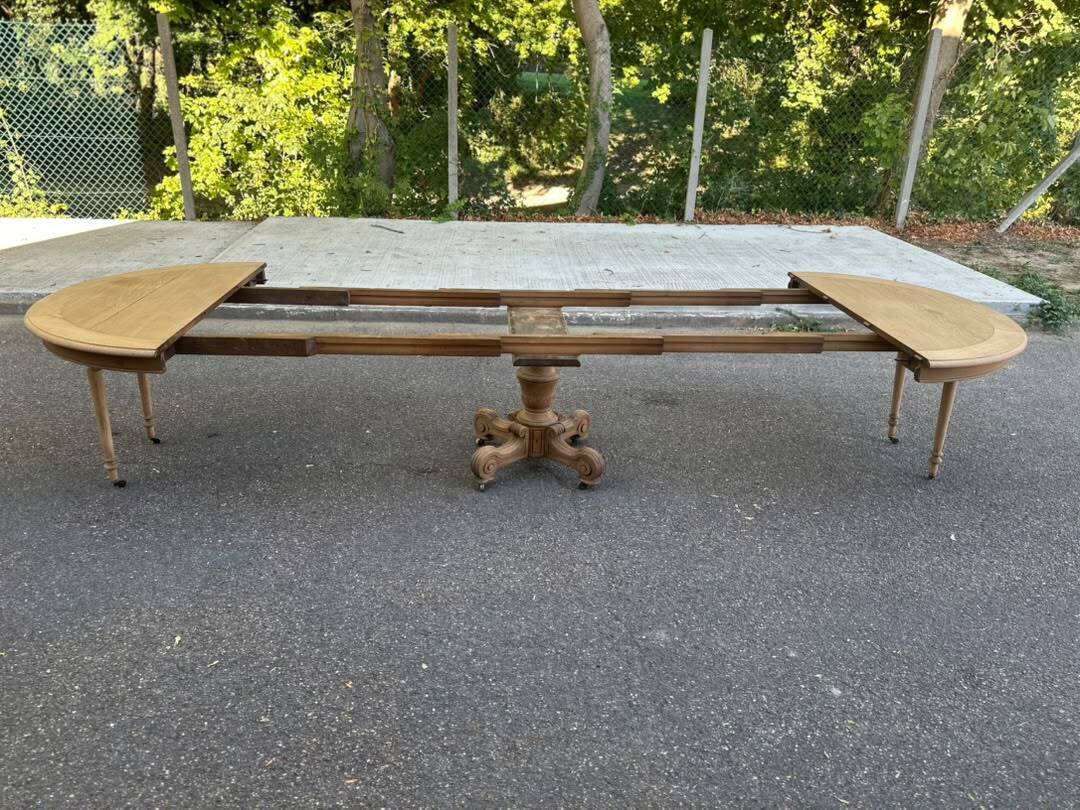 Round dining table with a central pedestal, stripped raw oak, 4 extensions, 19th century.
