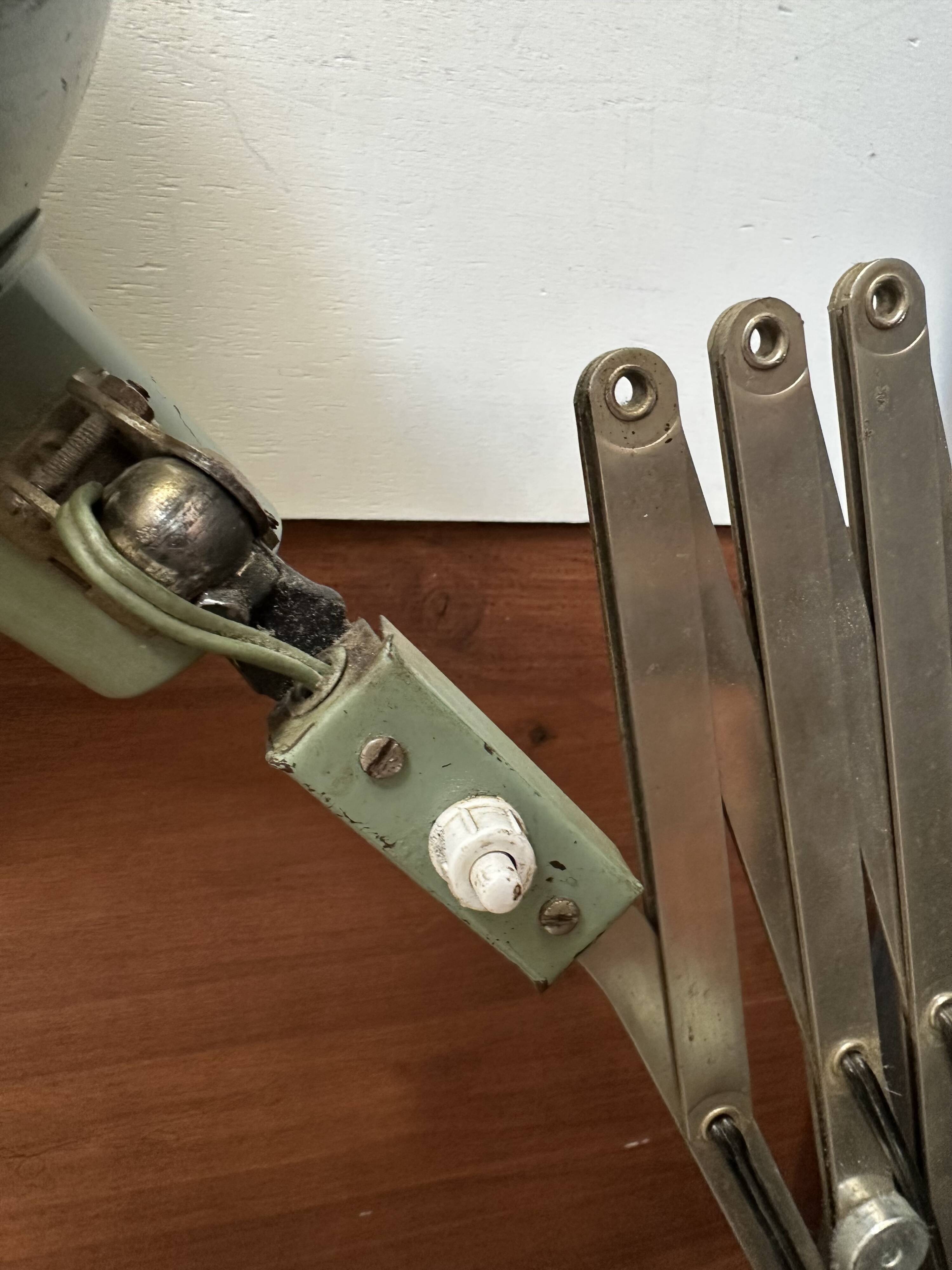 Old extendable accordion lamp in celadon green, workshop spirit.