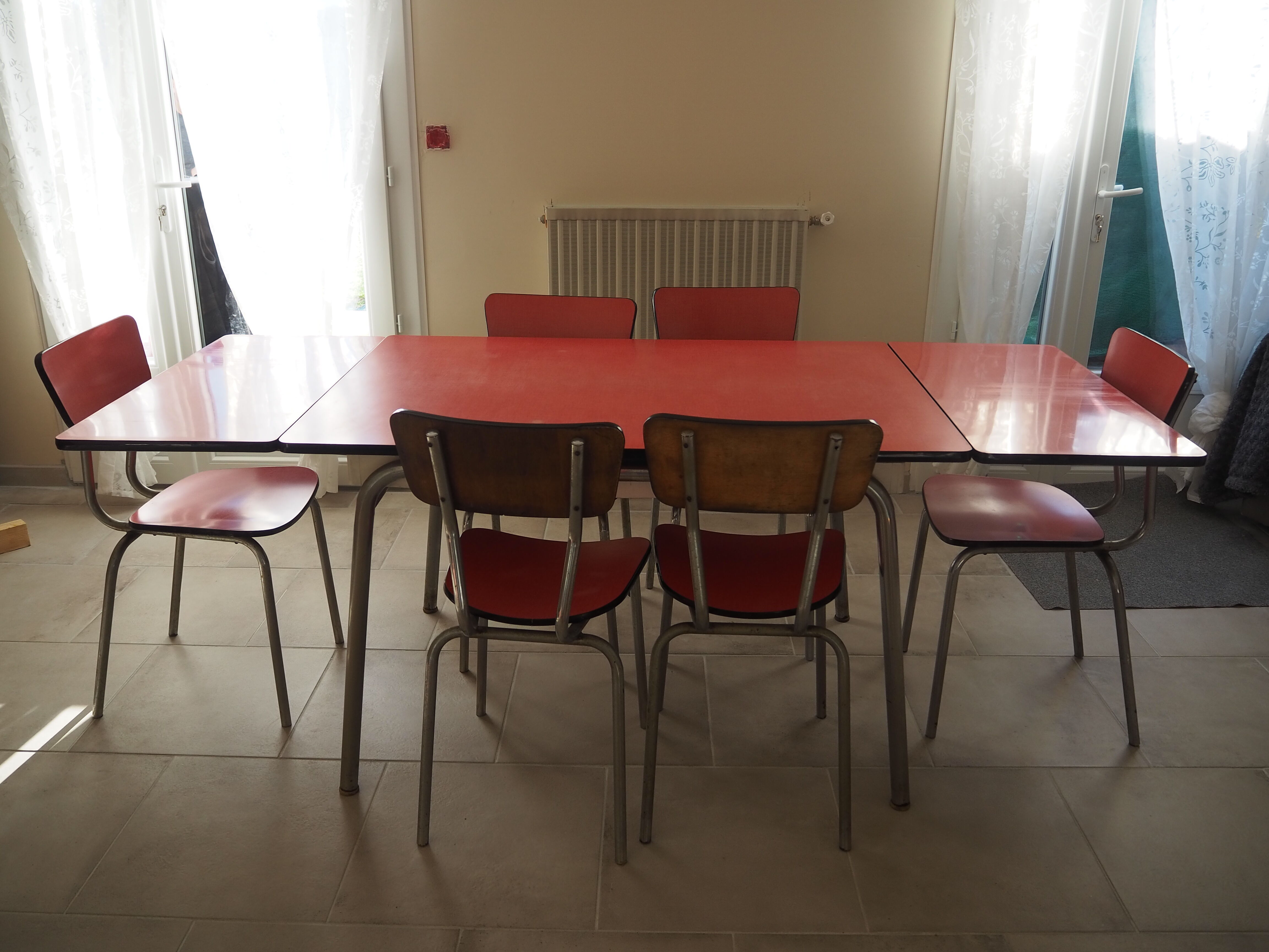 TABLE with two Italian EXTENSIONS and its 6 vintage CHAIRS of the 1970s in red color