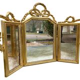 Triptych-shaped mirror in gilded wood and carved with a frieze