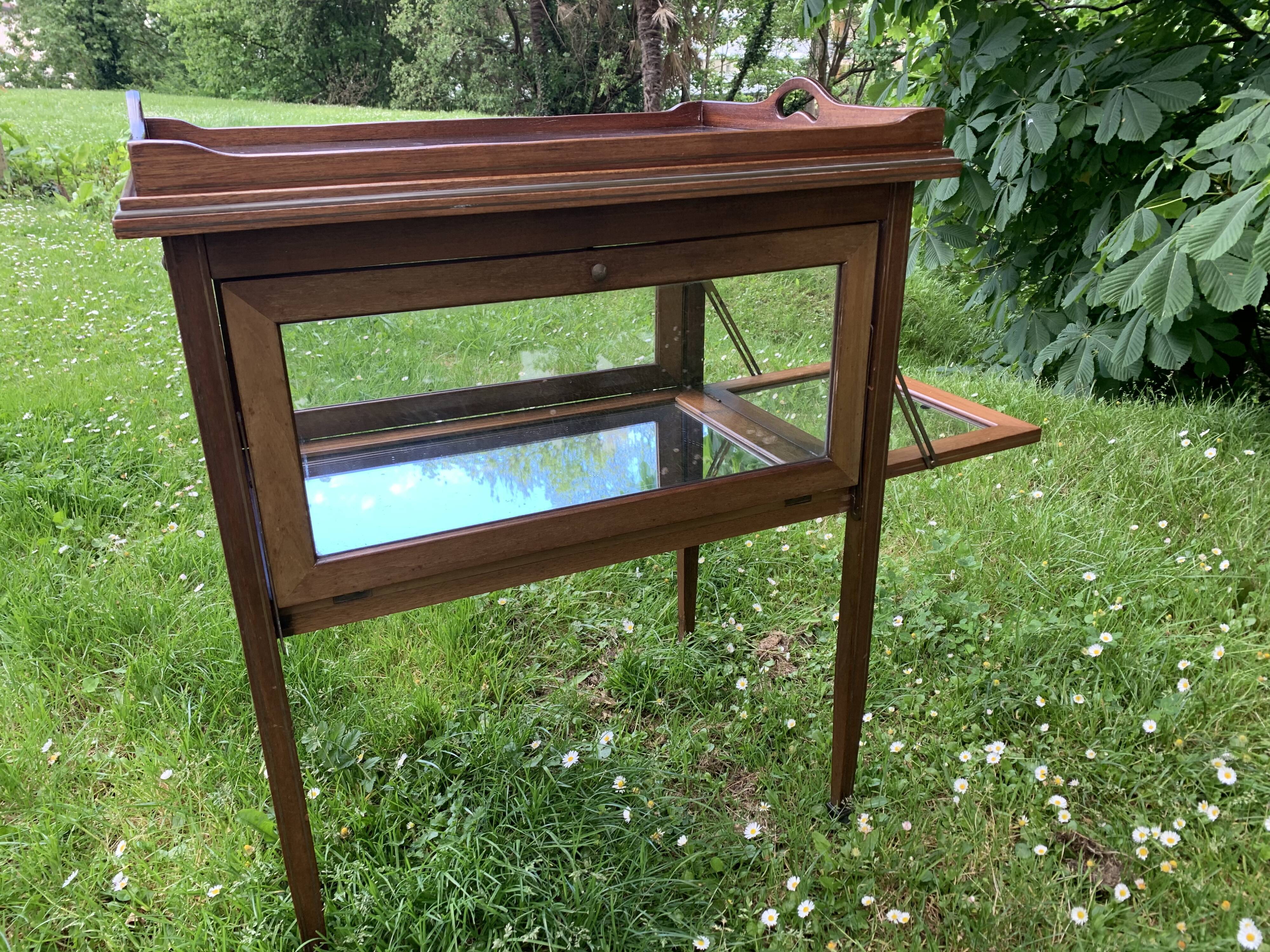 Glass-enclosed old tea table with wooden tray, bronze and brass