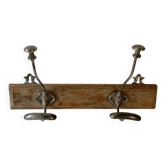 Pair of antique wrought iron coat hooks mounted on a wooden panel, 19th century