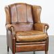 Cognac-colored sheep leather wingback chair finished with black piping