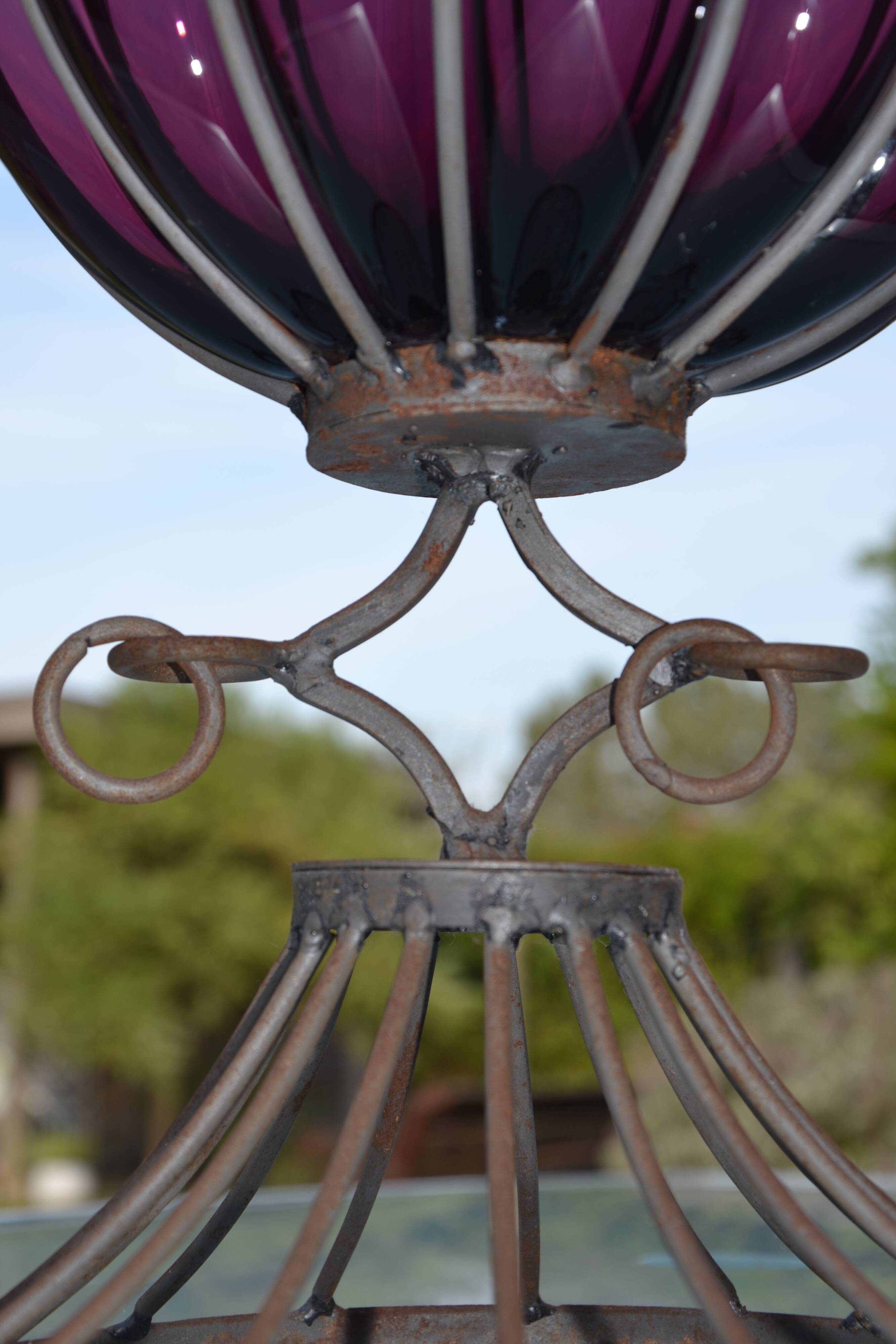 Large blown glass and wrought iron vase on shower stand