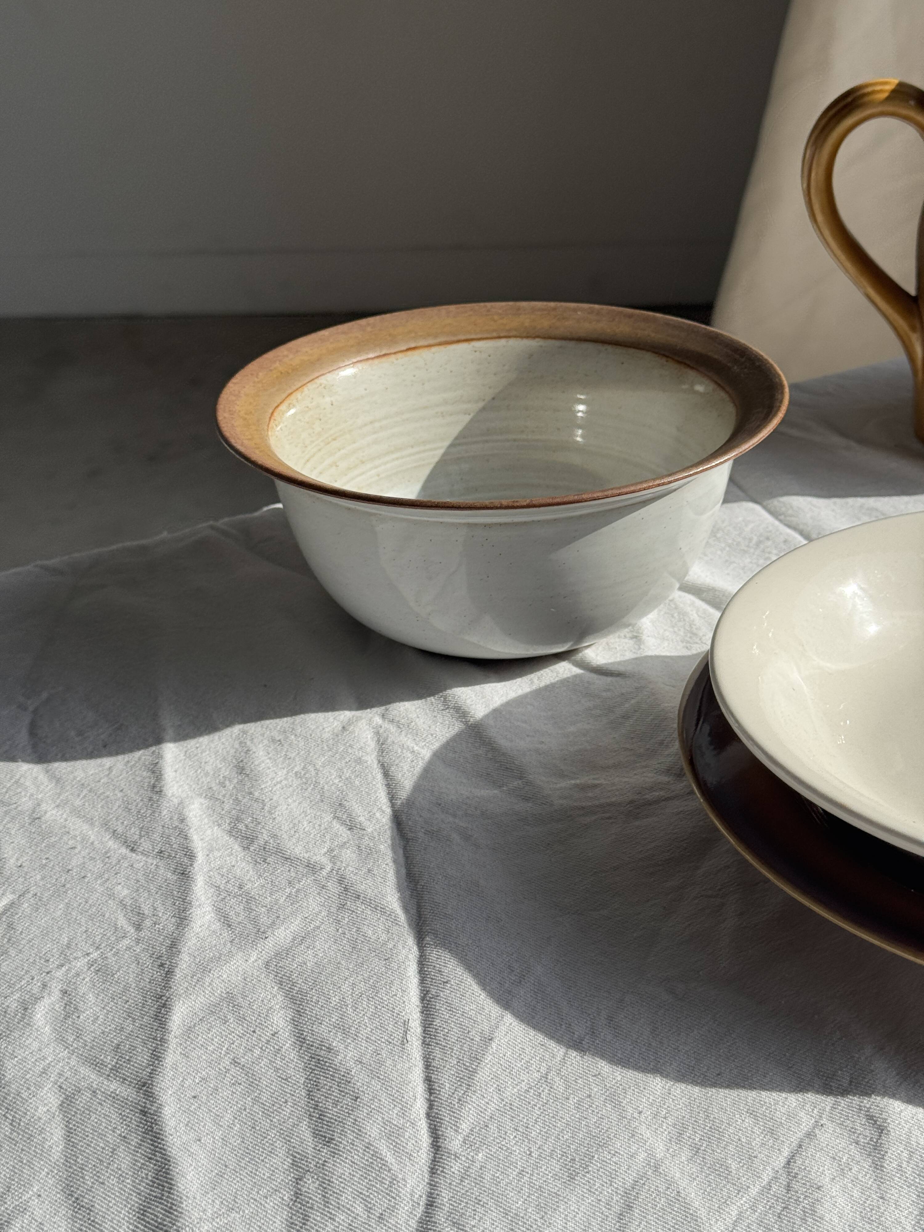 Small thick stoneware bowl with a stylised flower pattern in white on the outside, b