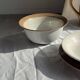 Small thick stoneware bowl with a stylised flower pattern in white on the outside, b