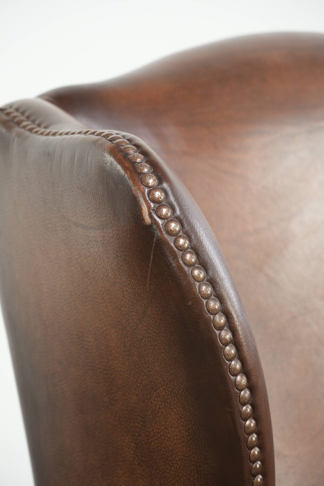 Cowhide wingback armchair in English style finished with decorative nails