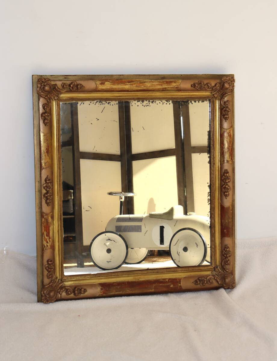 Rectangular mirror in gilded wood with relief decoration of flowers.
