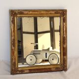 Rectangular mirror in gilded wood with relief decoration of flowers.