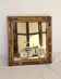 Miroir rectangulaire en bois doré à décor en relief de fleurs.