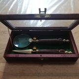 Magnifying glass and paper cutter in a vintage wooden box