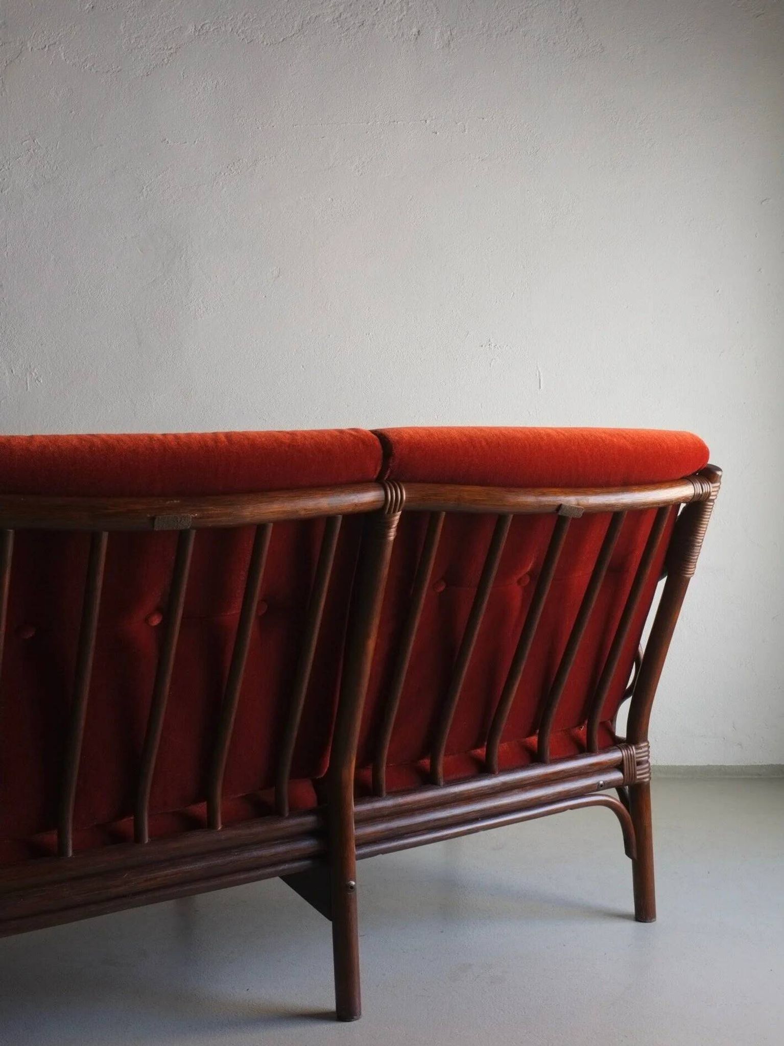 Dark rattan 3-seater sofa with red velour cushions | 1980s
