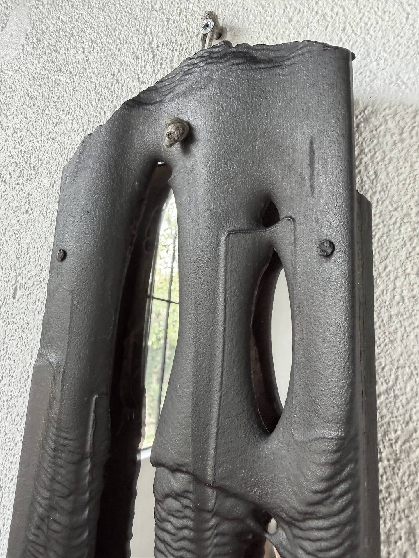 Brutalist hammered mirror, free-form, patinated metal.