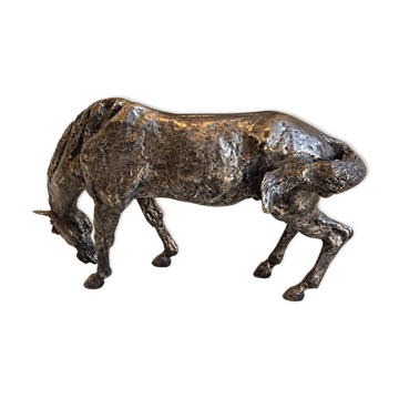 Sculpture of a grazing horse with a silver finish.