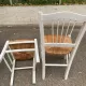 Set of 4 rustic white wooden chairs with straw seats.