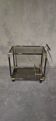 Black metal and brass rolling dessert trolley, smoked glass, 1970s.
