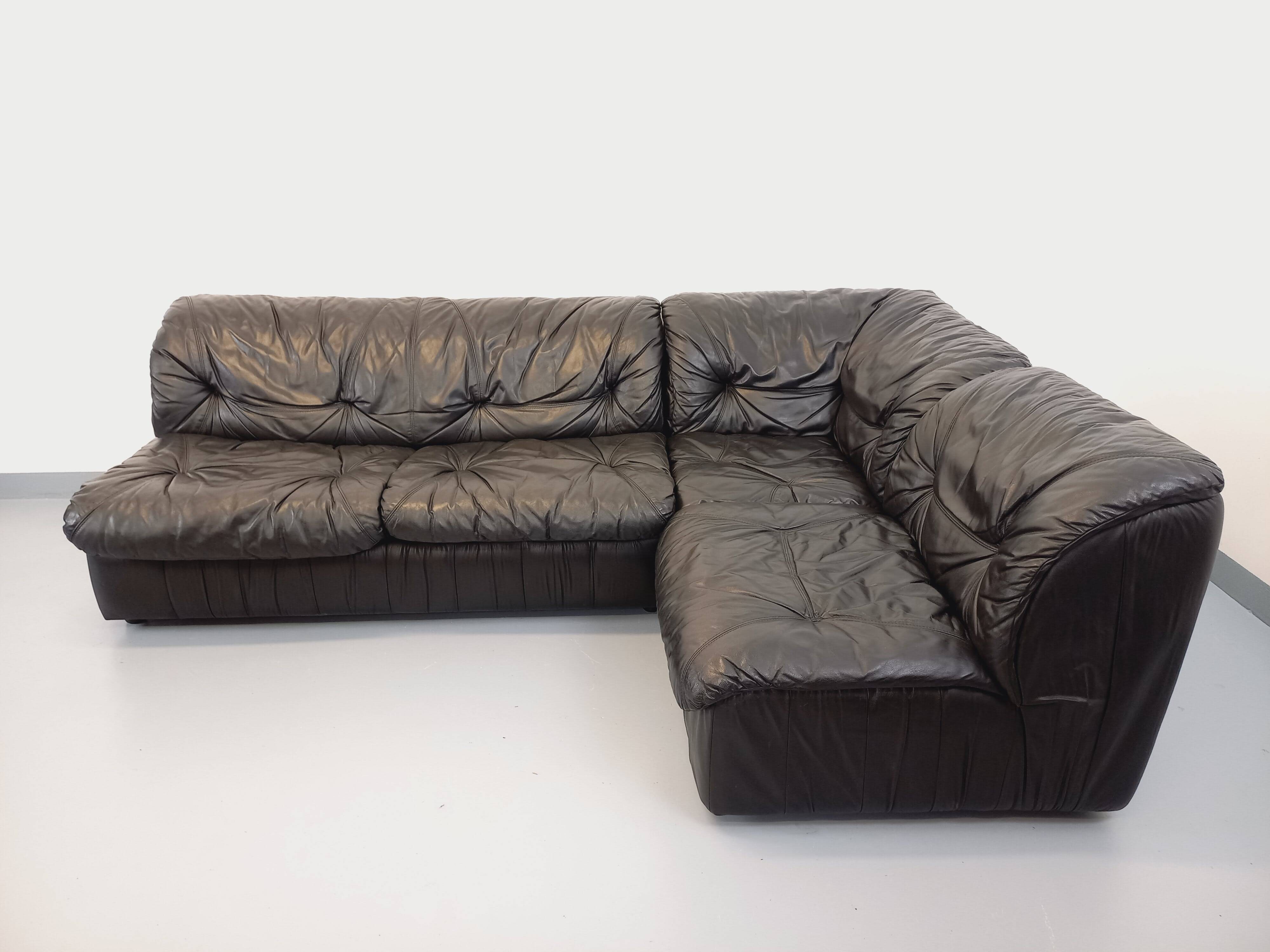 Vintage corner sofa composed of 3 modules in black leather with integrated bed.