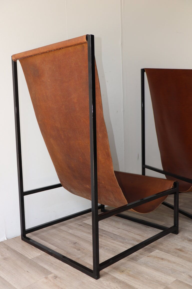Pair of vintage armchairs in stretched leather and metal structure