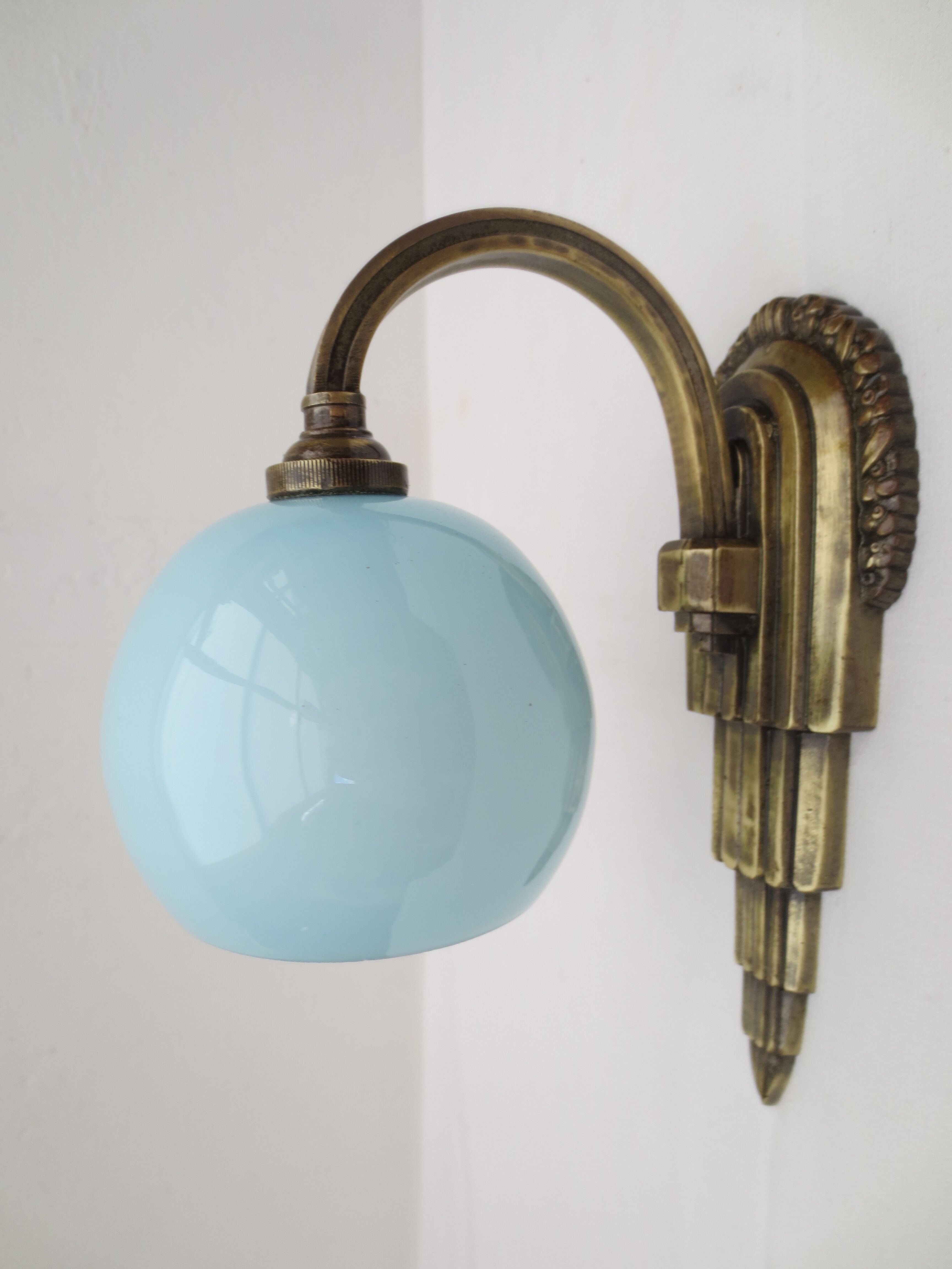 Art deco wall lamp in brass and soft blue opaline globe