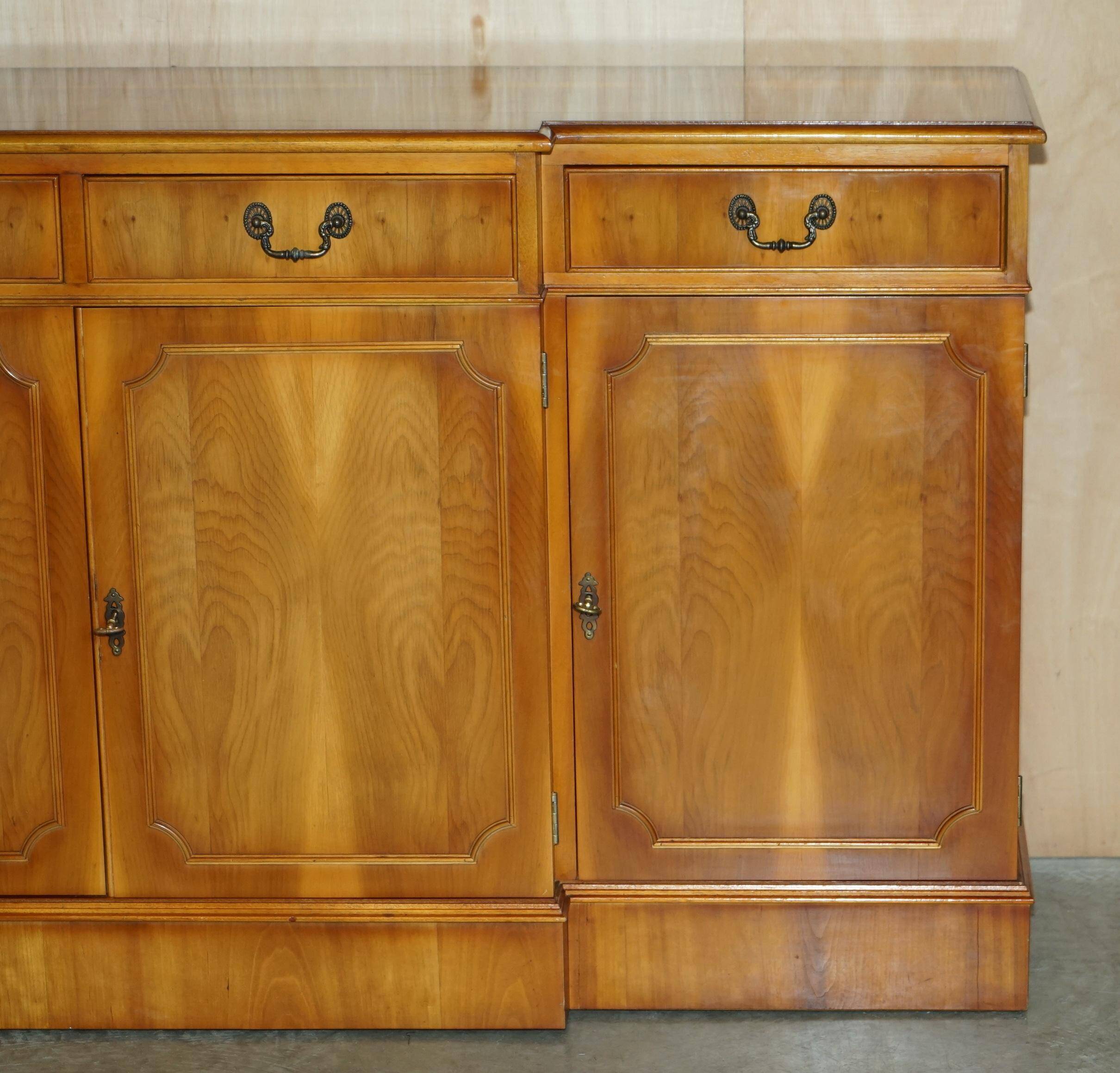 Vintage buffet made of mottled yew wood with three doors and four drawers.