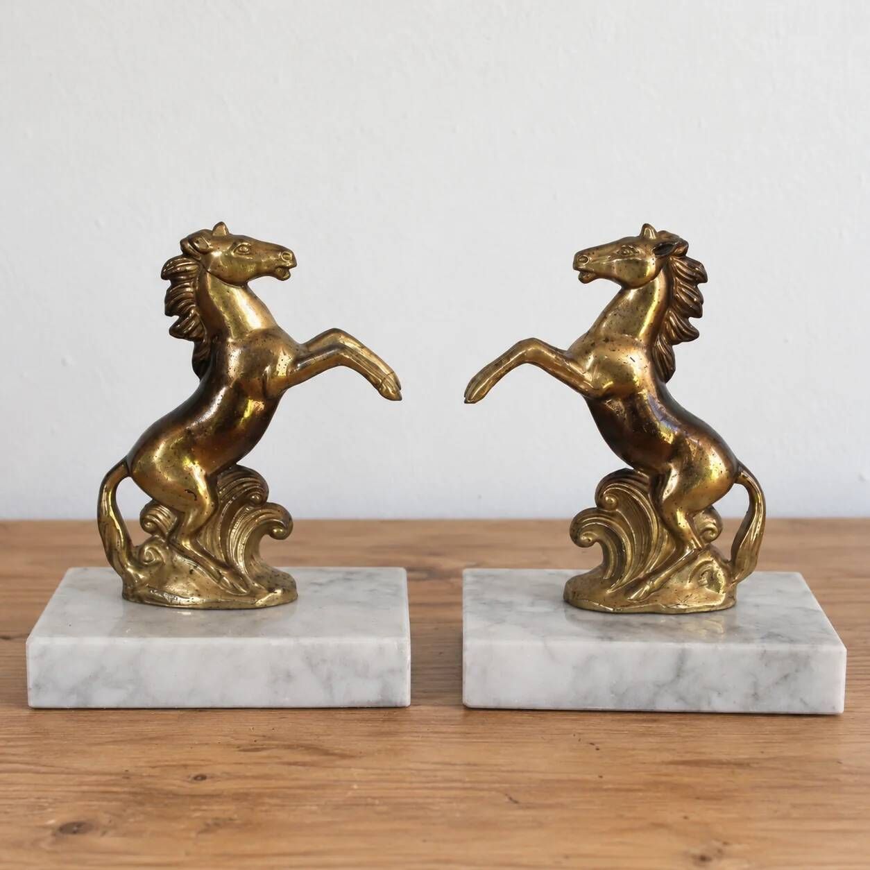 Pair of vintage bookends with rearing horses in gilded metal on marble bases.