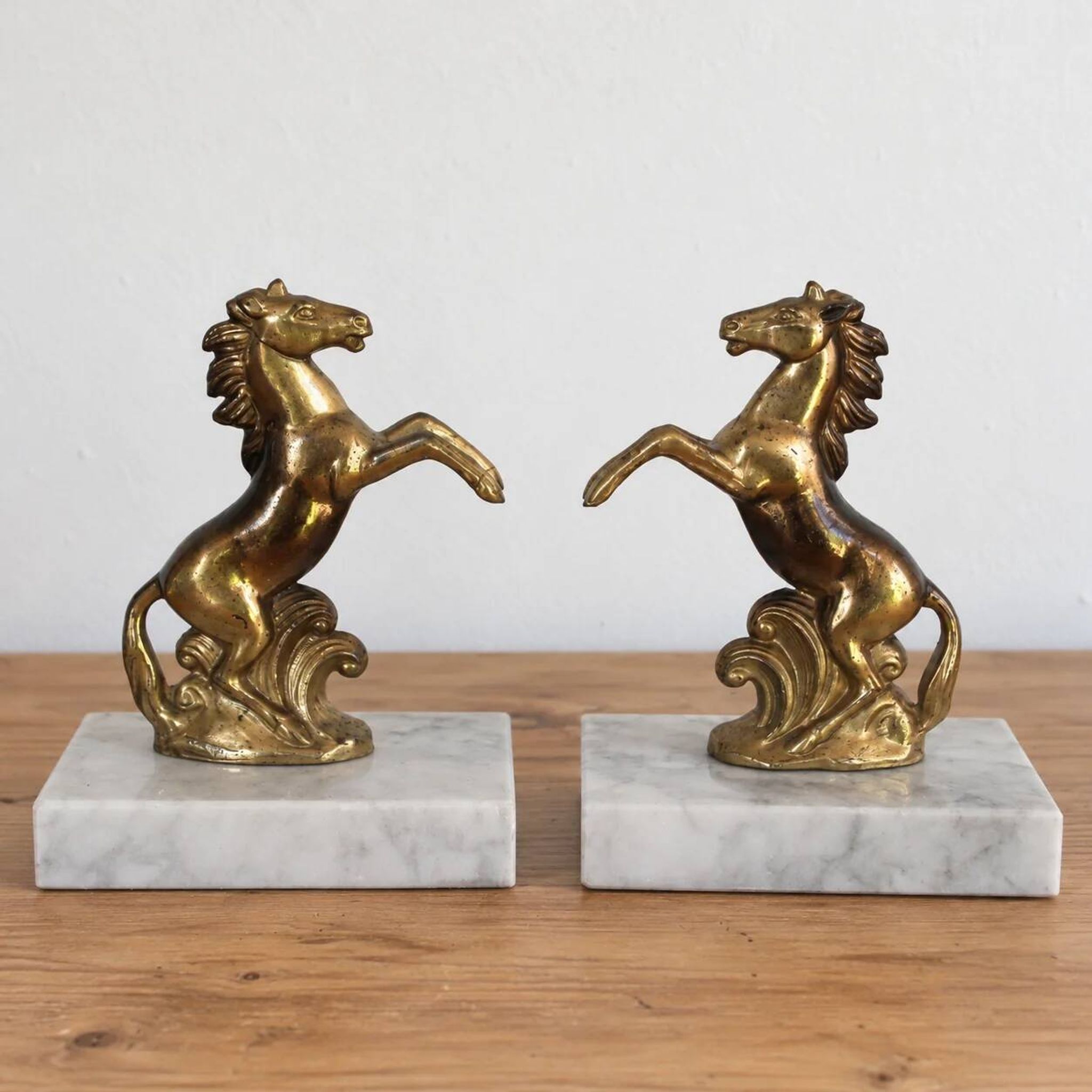 Pair of vintage bookends with rearing horses in gilded metal on marble bases.