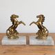 Pair of vintage bookends with rearing horses in gilded metal on marble bases.