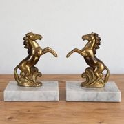 Pair of vintage bookends with rearing horses in gilded metal on marble bases.
