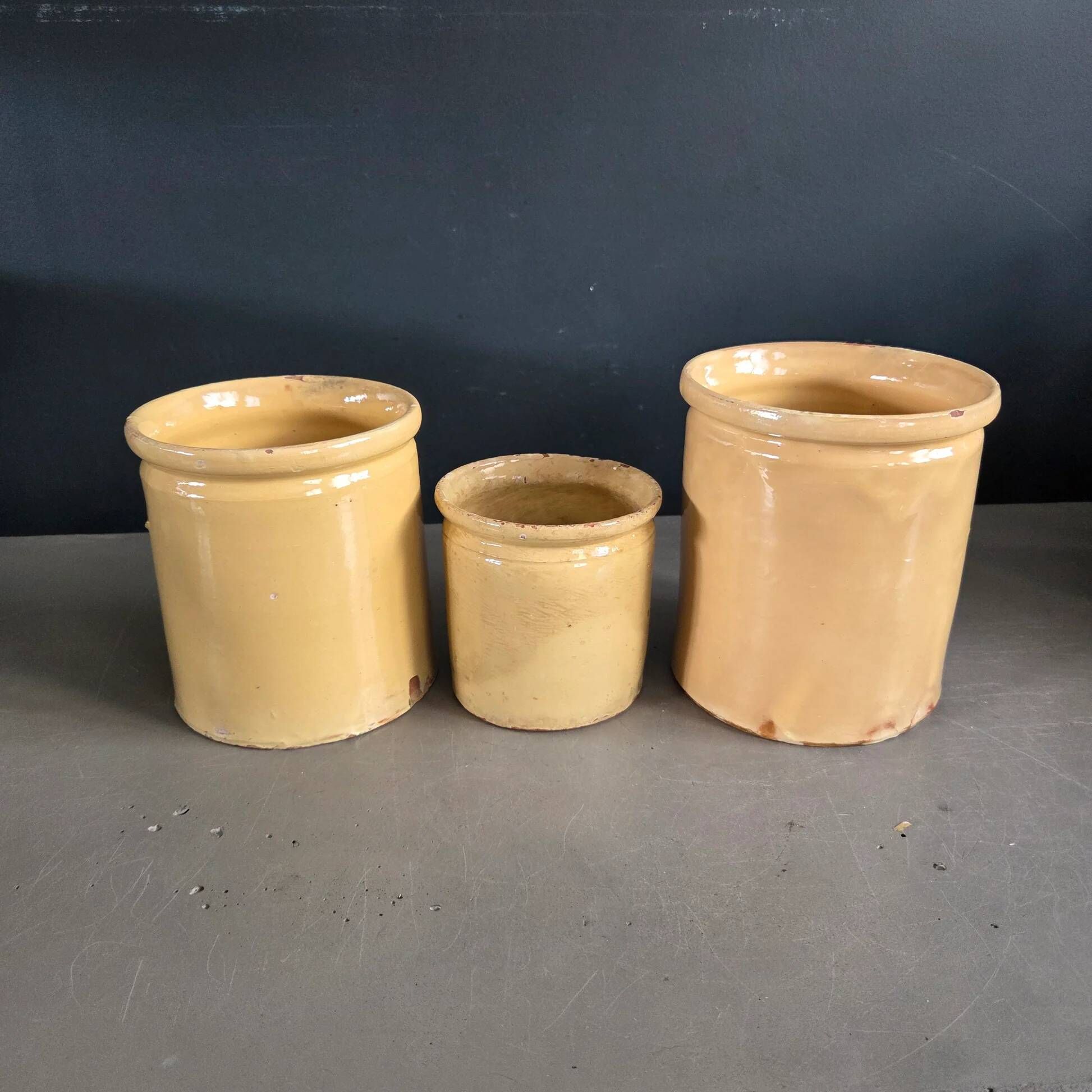 Trio of ancient pots in yellow glazed terracotta.